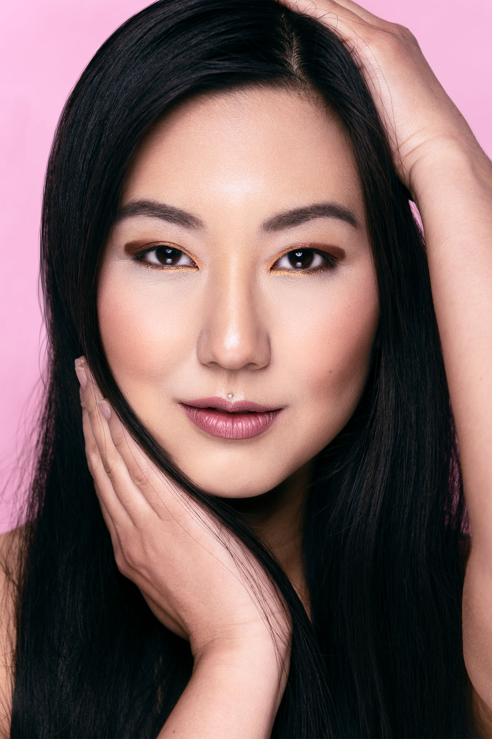 Beauty portrait of an Asian model looking straight at the camera with clean and beautiful makeup, smiling, long black hair by Utah photographer Christopher Loke